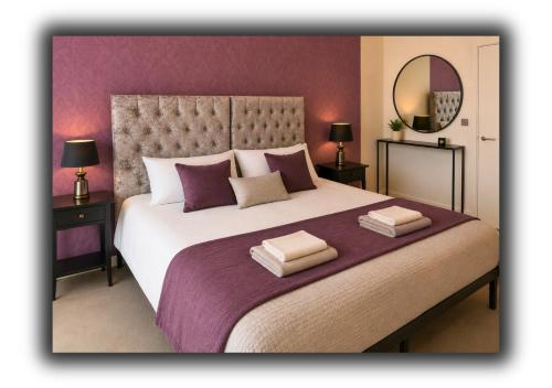a bedroom with a large bed with purple walls at The Vault Liverpool City Centre sleeps 4 in Liverpool