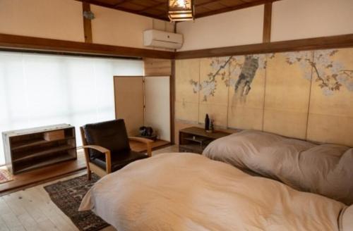 a bedroom with two beds and a desk and a chair at cottonTSUKECHI in Nakatsugawa