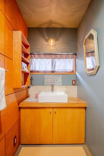 a small bathroom with a sink and a window at cottonTSUKECHI in Nakatsugawa