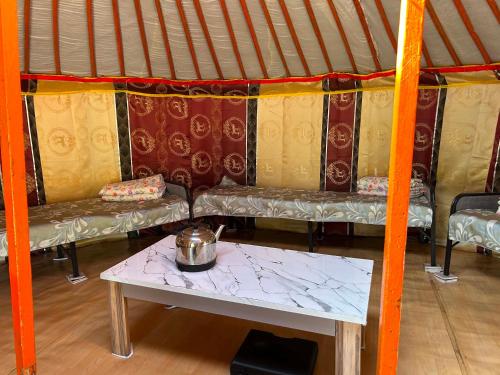 a room with a table and a couch in a yurt at Batzaya Herder Camp in Ulaanbaatar