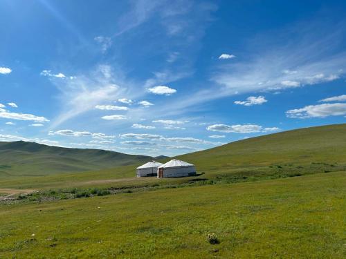 a white barn in the middle of a field at Batzaya Herder Camp in Ulaanbaatar