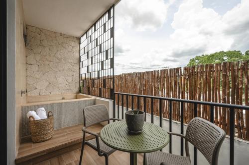 a balcony with a table and chairs and a tub at Suites con piscina privada - Penca Suites Valladolid in Valladolid