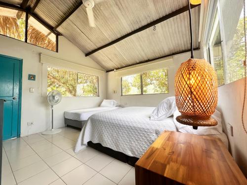 a bedroom with a bed and a table and windows at Isla Privada en Prado Piscina y Deportes Náuticos - Cerca a Bogotá - Cerca a Ibagué in Prado