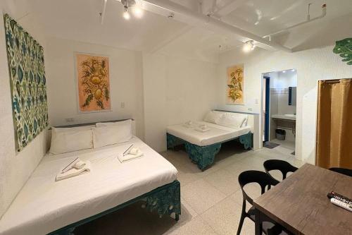a room with two beds and a table and a sink at 1001 Nights Boutique Inn in Cagayan de Oro