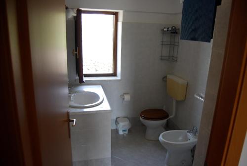 baño con lavabo y aseo y ventana en Dammusi Punta Fram en Pantelleria