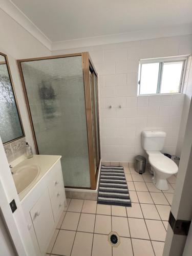 a bathroom with a shower and a toilet and a sink at Apartment on Henry in North Ward