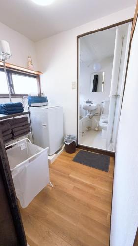 a mirror in a room with a sink and a bathroom at 無料駐車場付き 広々一軒家を最大5名様に貸し出し 家禄亭 in Okayama