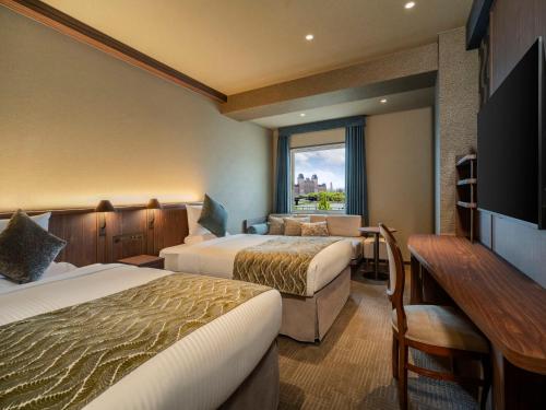 佐世保市にあるホテル ローレライのベッド2台と机のあるホテルの部屋
