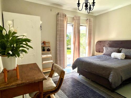 a bedroom with a bed and a desk and a window at SPAat343 in Roodeplaat