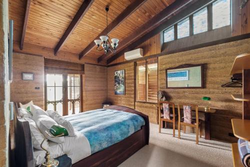 ein Schlafzimmer mit einem Bett in einem Zimmer mit Holzwänden in der Unterkunft Tea Tree - Pet Friendly - Prevelly - Margaret River in Margaret River Town