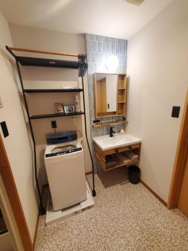 a small bathroom with a sink and a refrigerator at tomariel in Ō-shima