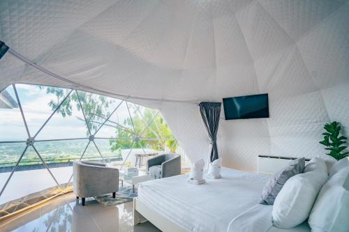 a bedroom with a white bed and a large window at Paradiso Khaokho By N in Ban Huai Phai