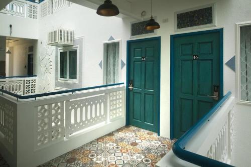 a hallway with two green doors and a slide at 1001 Nights Boutique Inn in Cagayan de Oro