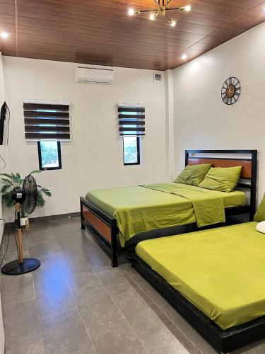a bedroom with two beds and a clock on the wall at Navia in Sañgitan