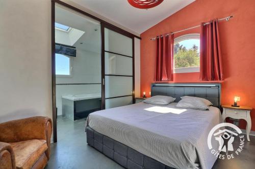 a bedroom with orange walls and a bed and a window at La grande maison in Orgères