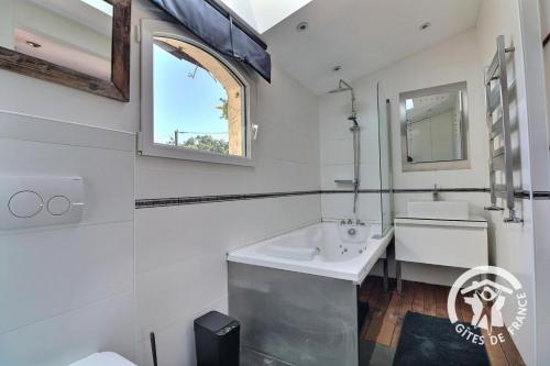 a white bathroom with a sink and a mirror at La grande maison in Orgères