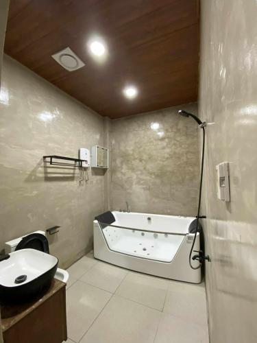a bathroom with a bath tub and a sink at Navia in Sañgitan
