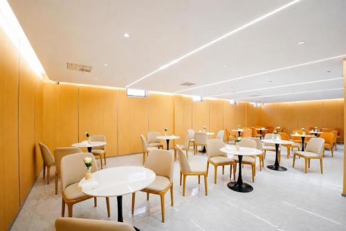 a dining room with white tables and chairs at Bishkek Crystal Luxury Smart Hotel Ala-Too Square Branch in Bishkek