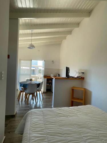 a bedroom with a bed and a table and chairs at Templanza in Villa Yacanto