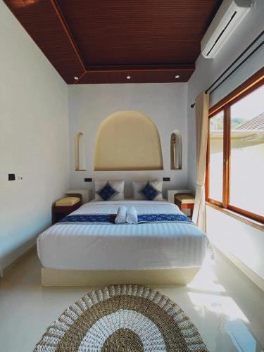 a bedroom with a large bed and a window at The Res Village Lombok in Kuta Lombok