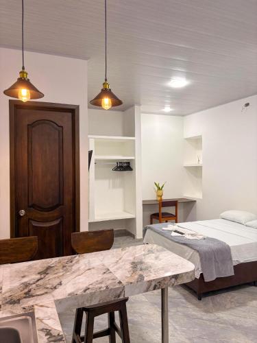 ein Schlafzimmer mit einem Bett, einem Tisch und zwei Lampen in der Unterkunft Aparta-Hotel LENEMBERGER in Puerto Asís