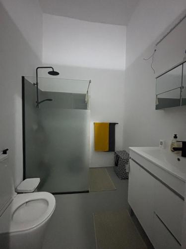 a white bathroom with a toilet and a sink at Casa Terra Odjo N'mar in Janela