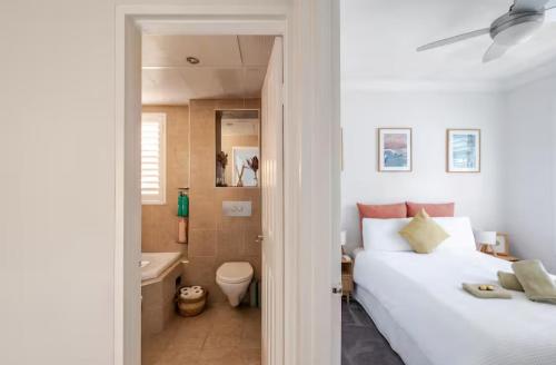 a bedroom with two beds and a bathroom at Lovley sunlit apartment walking distance to Cronulla mall and Cronulla Beach in Cronulla