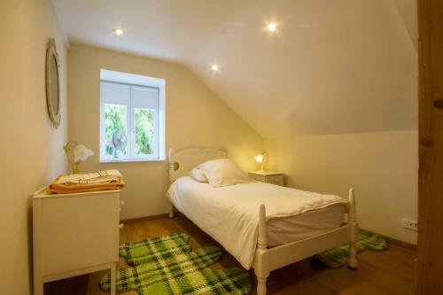 ein kleines Schlafzimmer mit einem Bett und einem Fenster in der Unterkunft L'esprit forêt in Les Forges