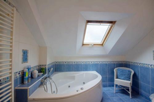 ein Badezimmer mit einer großen Badewanne und einem Fenster in der Unterkunft L'esprit forêt in Les Forges