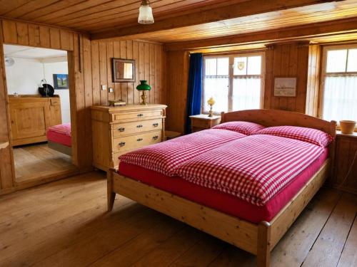 a bedroom with a bed with a red and white comforter at Revier Dorfidyll 1864 in Hätzingen