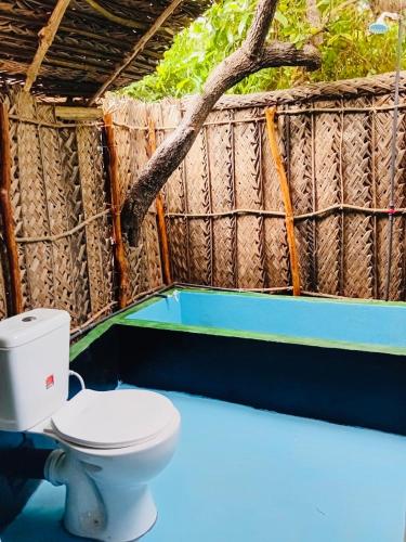 a bathroom with a toilet and a tree in it at Nilaveli Eco Lodge in Nilaveli