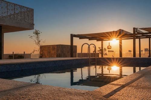 a swimming pool with a sunset in the background at Stella Stays Olaya Tower 1 - Furnished Apartments in Riyadh