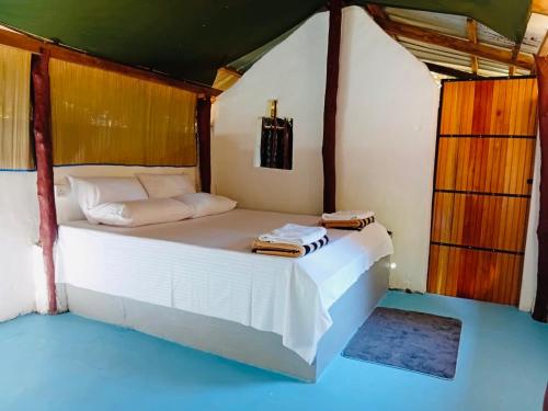 a bedroom with a white bed in a room at Nilaveli Eco Lodge in Nilaveli