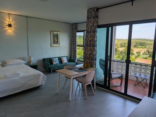 a bedroom with a bed and a table and a couch at Loei Valley Farm Stay in Wang Saphung