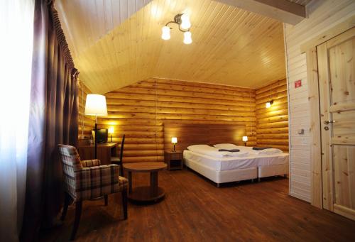 1 dormitorio con 1 cama en una habitación con paredes de madera en Terrassa Park, en Burabay