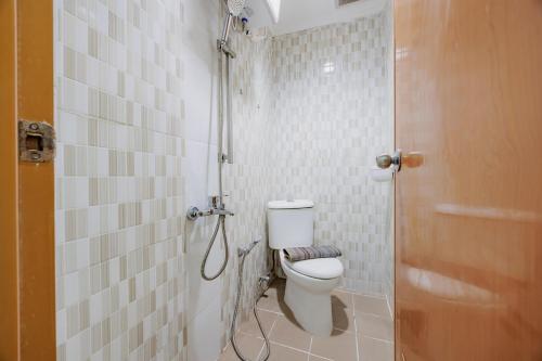 a small bathroom with a toilet and a shower at RedDoorz Near MRT Bendungan Hilir in Jakarta