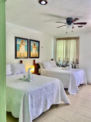 a bedroom with two beds with a swan on them at Pelican Inn at Las Dunas Chelem in Chelem