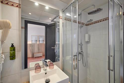 a bathroom with a shower and a sink and a mirror at Hotel Navia Santa Ponsa - Adults Only in Santa Ponsa
