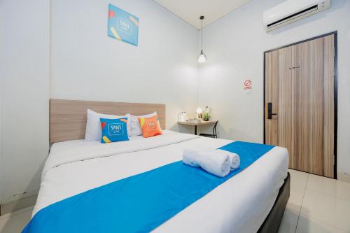 a bedroom with a large bed with colorful pillows at Sans Vibes Hotel Malabar in Bandung