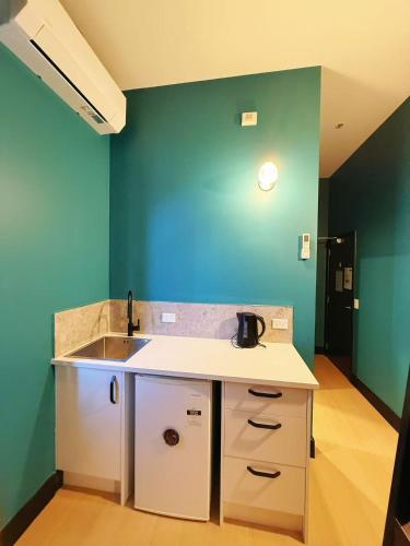 a kitchen with a sink and a blue wall at Georgie Accommodation in Auckland