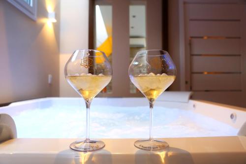 two glasses of white wine sitting on a table at Zaya Motel Premium in Florianópolis