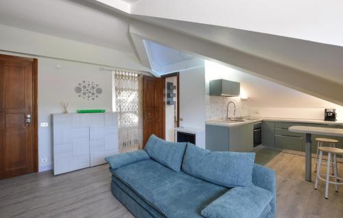 a living room with a blue couch and a kitchen at Awesome Apartment In Millesimo With Wifi in Millesimo
