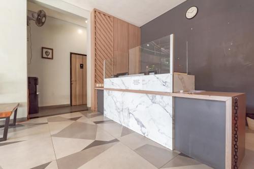 a marble counter in a kitchen with a clock on the wall at Sans Vibes Hotel Malabar in Bandung
