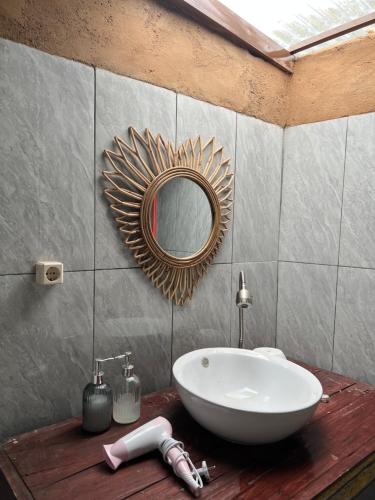 a bathroom with a sink and a mirror on a counter at Sun Grace Villa and Camp in Sembalun Lawang