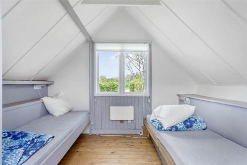 a attic room with two beds and a window at FY273-Millinge-Buursminde-2 in Millinge