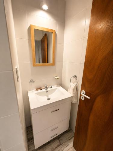 a bathroom with a white sink and a mirror at Alta Vista in Villa Yacanto