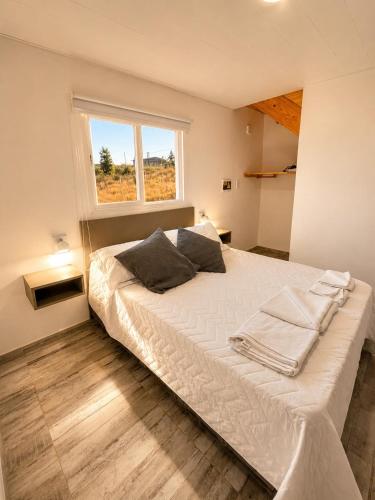 a large white bed in a room with a window at Alta Vista in Villa Yacanto