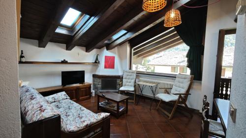 a living room with a couch and chairs and a television at Le Perce Neige in Morgex