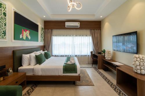 a hotel room with a bed and a tv at Mangalam Resort & Spa - Member of Absolute Collection in Aurangabad