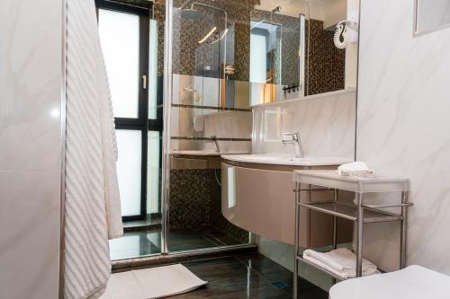 a bathroom with a sink and a mirror at Hotel Victor in Mamaia